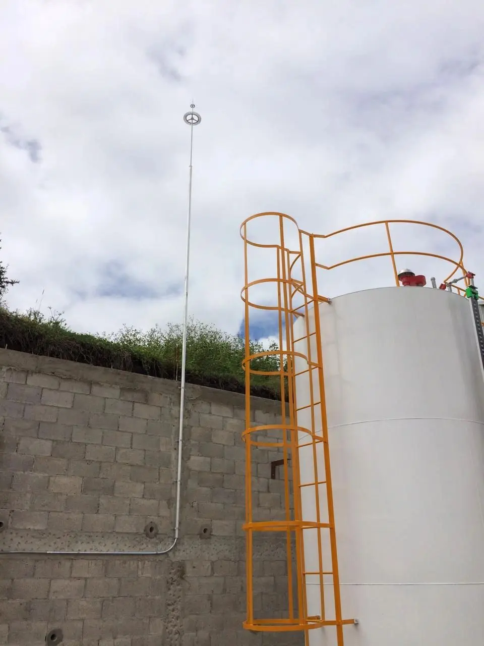 Pararrayos instalado junto a un tanque industrial con escalera de seguridad
