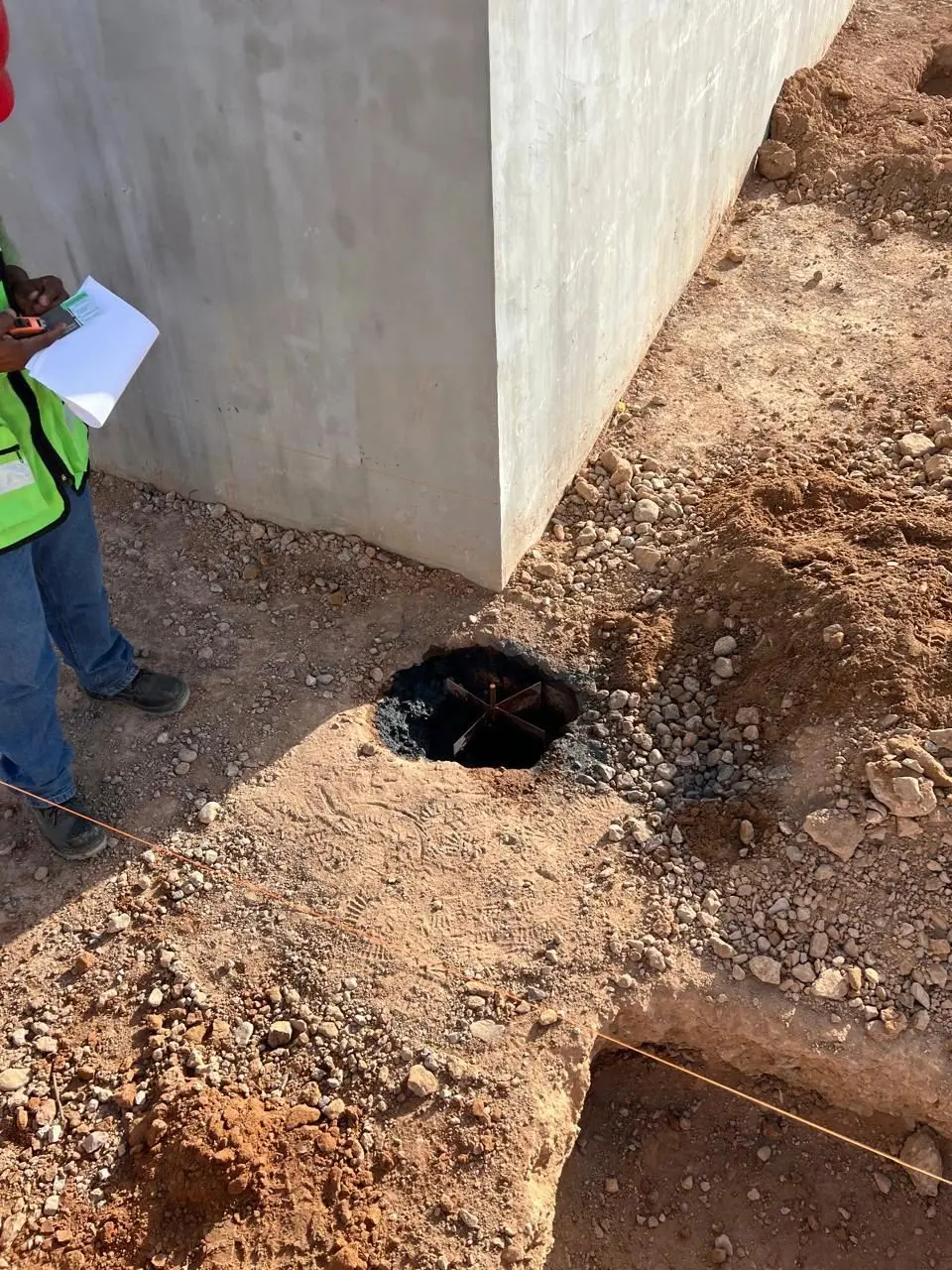 Técnicos excavando junto a un muro para instalar el sistema de tierra física